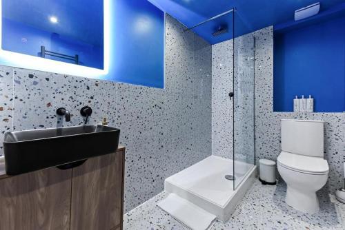 bagno con servizi igienici, lavandino e soffitti blu di Gorgeous Home in Islington a Londra