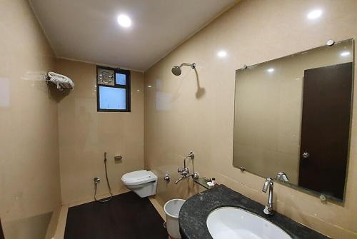 a bathroom with a sink and a toilet and a mirror at Hotel Montana NX in Lonavala