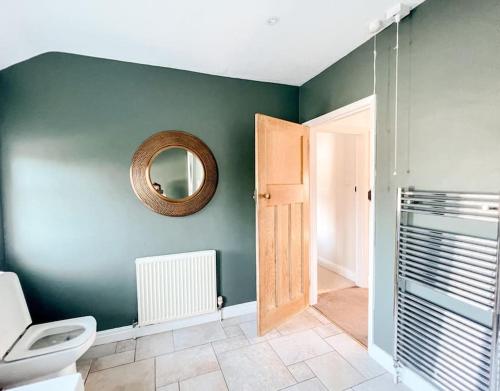 Home in Hereford في هيريفورد: حمام مع مرحاض ومرآة على الحائط