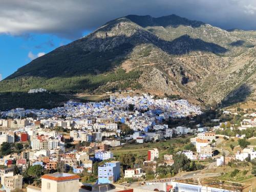 an aerial view of a city with mountains in the background at Dar Saphire Apartments in Chefchaouen
