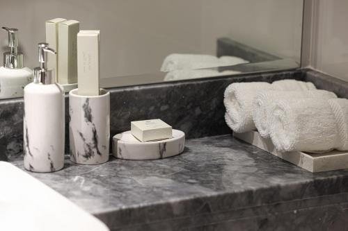 a bathroom with a counter with towels and a mirror at Visionary Vista: 2BR Al Habtoor City in Dubai