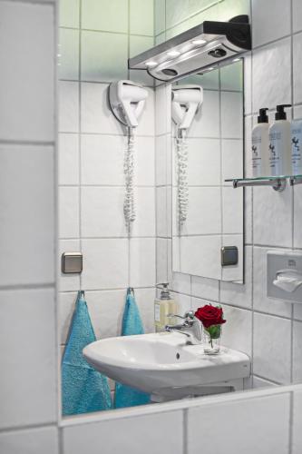 une salle de bain avec un lavabo et un miroir dans l'établissement Best Western Tidbloms Hotel, à Göteborg