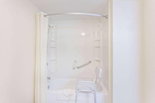 a white bathroom with a white tub and a white chair at Super 8 by Wyndham Knoxville West/Farragut in Knoxville