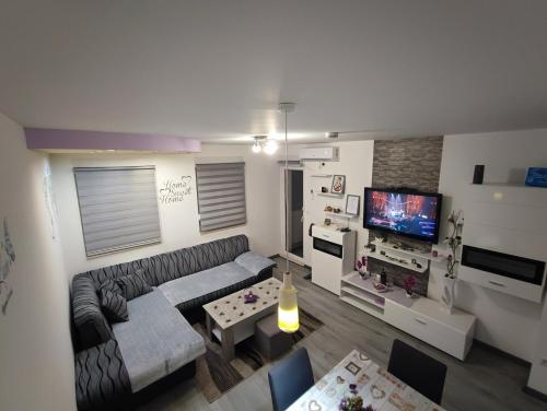 een woonkamer met een bank en een tv bij Stan na dan Apartman KRISFIL Prnjavor in Prnjavor