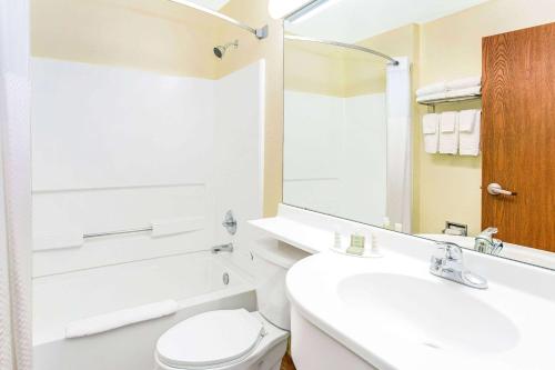 a bathroom with a toilet and a sink and a mirror at Super 8 by Wyndham Parker/SE Denver Area in Parker