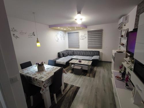 een woonkamer met een bank en een tafel bij Stan na dan Apartman KRISFIL Prnjavor in Prnjavor