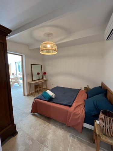 a bedroom with a large bed and a chandelier at Le mazet de fabrègues in Fabrègues