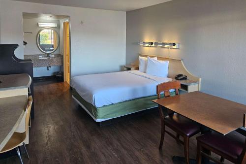 um quarto de hotel com uma cama e uma mesa em Rodeway Inn & Suites Thousand Palms - Rancho Mirage em Thousand Palms