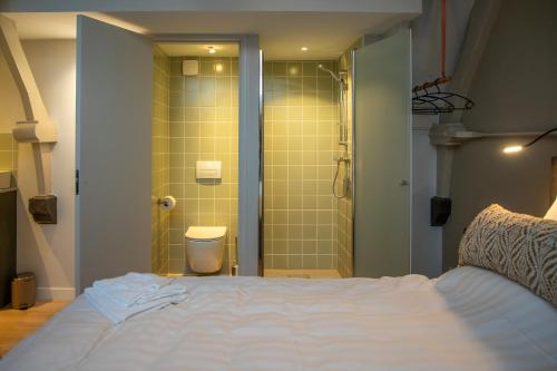 a bedroom with a bed and a shower in a bathroom at B&B de oude melkfabriek in Valkenswaard