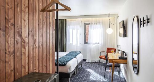 ダンケルクにあるBest Western Plus Hotel Cargoのベッドとデスクが備わるホテルルームです。