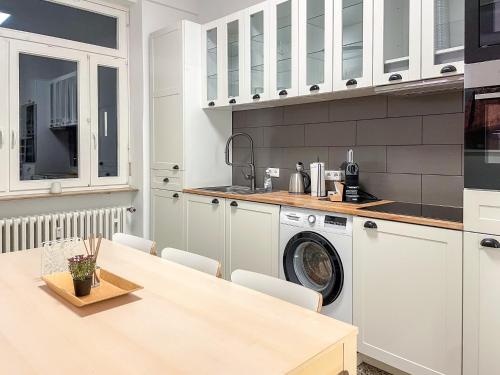 een keuken met een wasmachine en een tafel bij namastay! - Stilvoll mit Blick auf den Wasserturm in Mannheim
