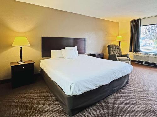 una camera d'albergo con un grande letto e una sedia di Econo Lodge a Kannapolis