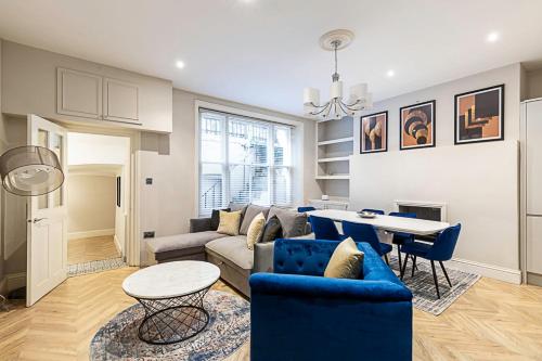 een woonkamer met een bank en een tafel bij Beautiful Two Bedroom Abode in Notting Hill in Londen