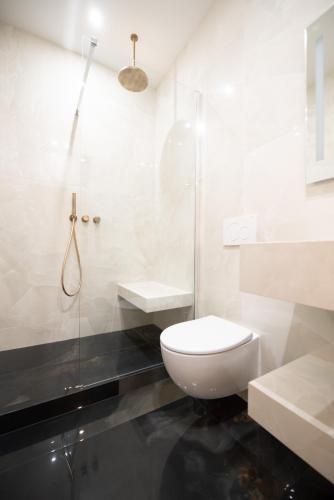 une salle de bain blanche avec toilettes et douche dans l'établissement Luxury Flat - Opera & Upper Marais, à Paris