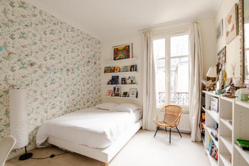 - une chambre avec un lit et du papier peint floral dans l'établissement Veeve - Aesthetic Artistry, à Paris