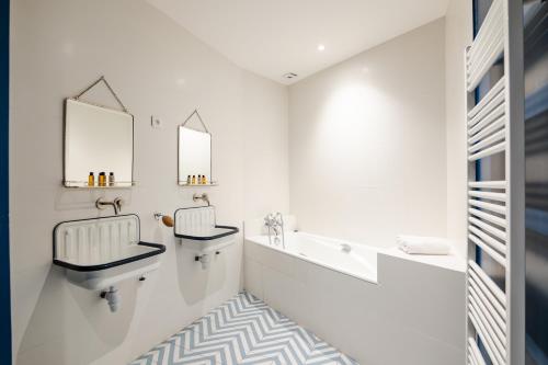 une salle de bain avec deux lavabos et un miroir dans l'établissement Veeve - Aesthetic Artistry, à Paris