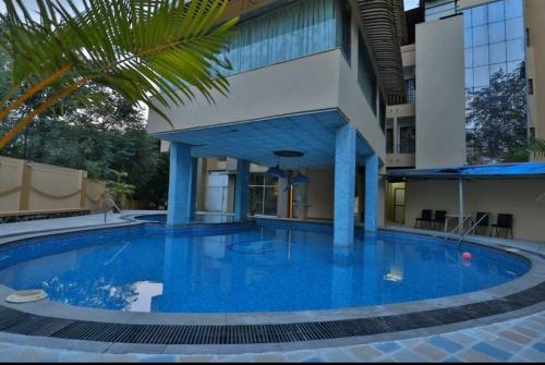 a large blue swimming pool in front of a building at Retreat Heritage in Lonavala