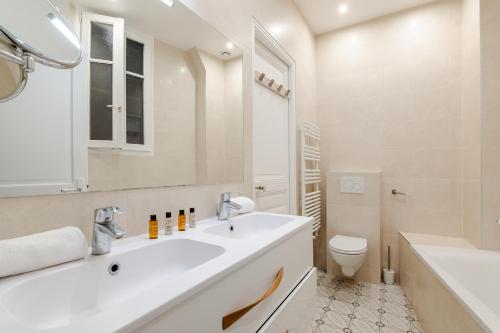 une salle de bain blanche avec un lavabo et des toilettes dans l'établissement Veeve - Magic of Light, à Paris