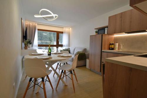 een keuken met een tafel en stoelen in een kamer bij SWEET Alps Apartment CCM in Madonna di Campiglio