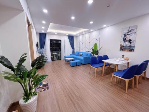 a living room with a blue couch and a table and chairs at FLC SEA TOWER QUY NHƠN ban công, bồn tắm, hồ bơi có phí, sát biển in Quy Nhon