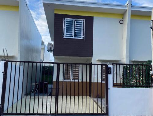 ein Haus mit einem schwarzen Tor und einer weißen Tür in der Unterkunft Villa de Steph in San Pablo City