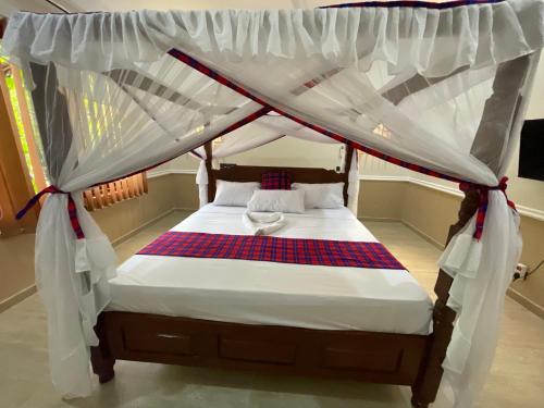 a bed with a canopy in a room at Maasai Koroga in Mombasa