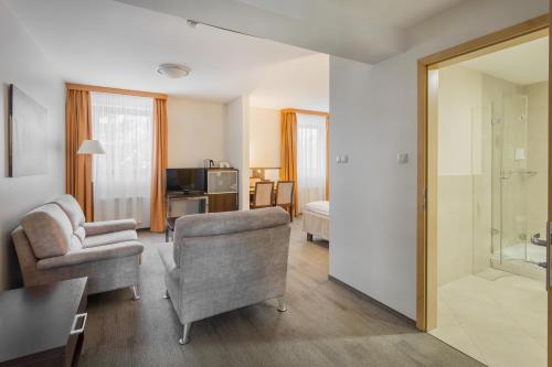 sala de estar con sofá y silla en Hotel Orange Przeźmierowo, en Przeźmierowo