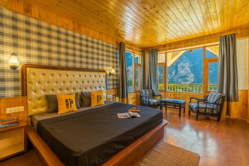 a bedroom with a bed and a large window at The Hosteller Manali, Old Manali in Manāli