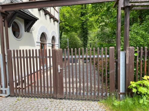 una recinzione di legno di fronte a un edificio di Pension Parkschlösschen a Lichtenstein