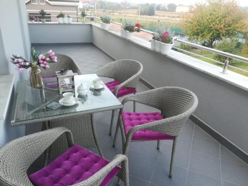 un tavolo con sedie imbottite viola su un balcone di Eli's luxury apartment a Zagabria