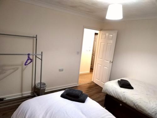 a bedroom with two beds and a hallway with a door at Comfort Private Rooms in Three bedroom House in Bridgemary