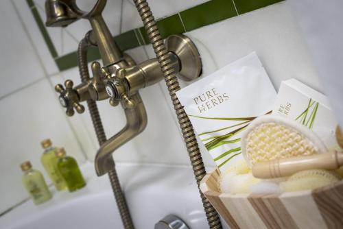 a bathroom sink with a faucet and a basket of butter at La Llave de la Judería Hotel Boutique in Córdoba