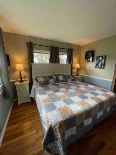 a bedroom with a bed with a checkered blanket on it at Bourbon Trail Cabin on the Farm in Lawrenceburg