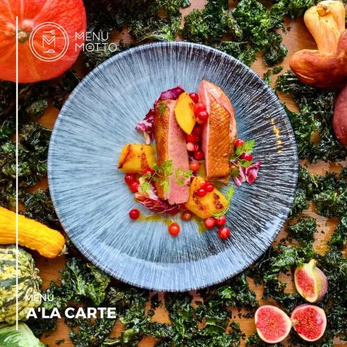 a blue plate with meat and fruit on a table at Invite in Wrocław