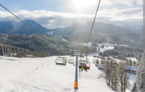 a ski lift on a ski slope with people on it at Villa Fortuna Natur in Lackenhof
