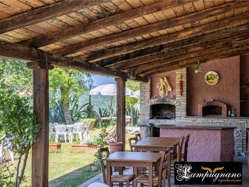 eine Terrasse mit einem Tisch und einem Backofen im Freien in der Unterkunft Lampugnanino in Civitella Marittima