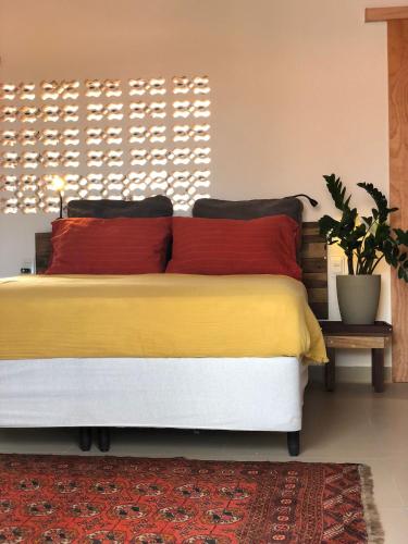 een slaapkamer met een bed met rode en gele kussens bij Casa Brigita. Fortaleza in Fortaleza