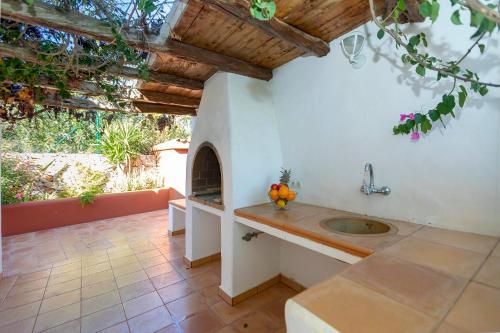 an outdoor kitchen with a sink and an arbor at Villa in San Jose sleeps 10 - Sa Vinya in Sant Josep de Sa Talaia