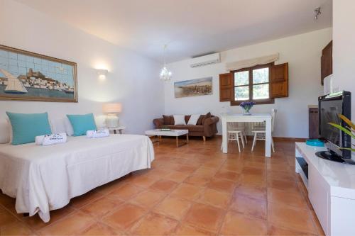 a bedroom with a bed and a living room at Villa in San Jose sleeps 10 - Sa Vinya in Sant Josep de Sa Talaia