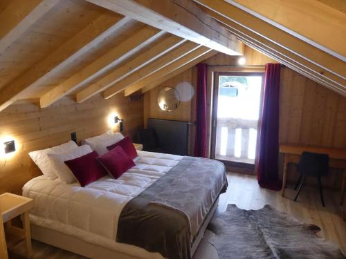 a bedroom with a large bed and a large window at Chalet le Nid independant mountain chalet in Morzine