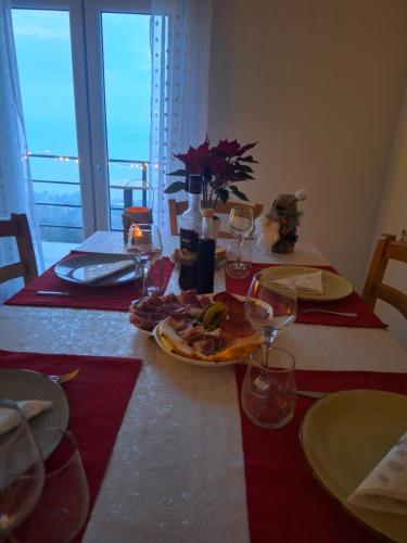 een tafel met een bord eten en wijnglazen bij Sunset in Lovran