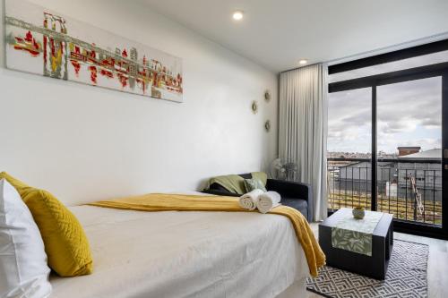 een slaapkamer met een bed en een groot raam bij *One On Albert 511*Studio Apartment - Swimming Pool, WI-FI & Netflix* in Kaapstad