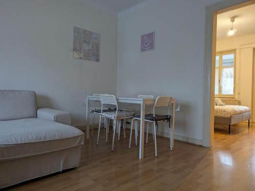 un salon avec une table, des chaises et un canapé dans l'établissement Le Bâlois - appartement 2 chambres, salon, cuisine équipée, parking et wifi gratuit, à Mulhouse