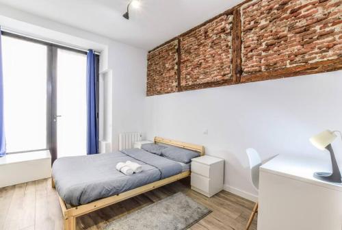 馬德里的住宿－Unique flat La Latina * Billiard & Darts，一间卧室设有一张床和砖墙
