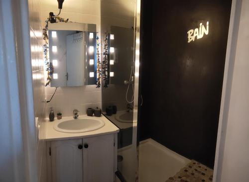a bathroom with a sink and a mirror at La Perle Marine, joli appartement avec 1 chambre, Cosy et rénové à 200 m de la plage, vue Marina des Quilles, parking et Wifi in Sète