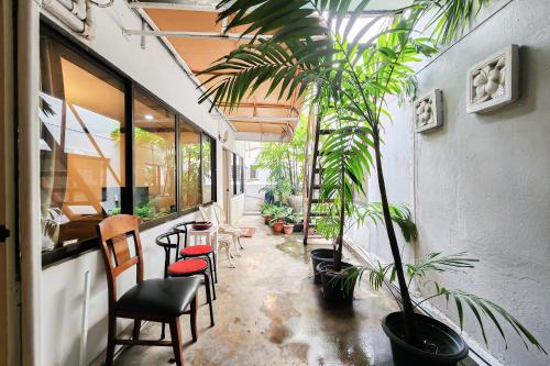 a room with chairs and a table and plants at Cordia Residence Sathorn in Bang Rak