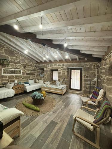 a large living room with a stone wall at Aturuxo, Casa dos Mestres in Trasmiras