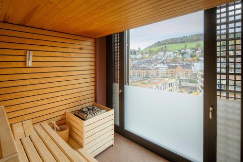 a room with a sauna with a large window at Tailormade Hotel LEO St Gallen in St. Gallen