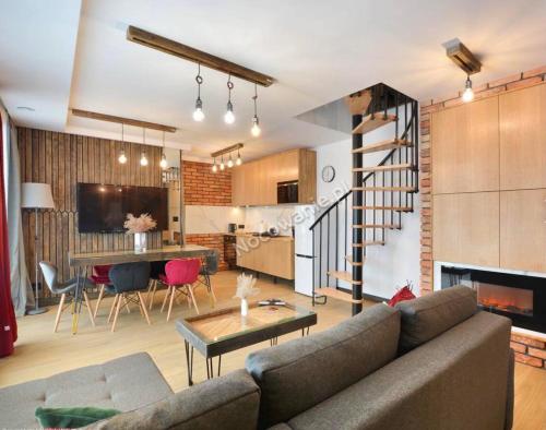 Una sala de estar y una cocina con un sofá y una mesa. en Bystre DOMKI, en Nowe Bystre