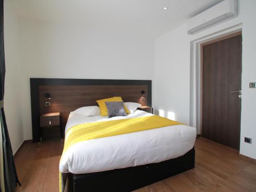 Schlafzimmer mit einem großen Bett mit einem Kopfteil aus Holz in der Unterkunft Gîte Rouffach, 3 pièces, 4 personnes - FR-1-744-16 in Rouffach
